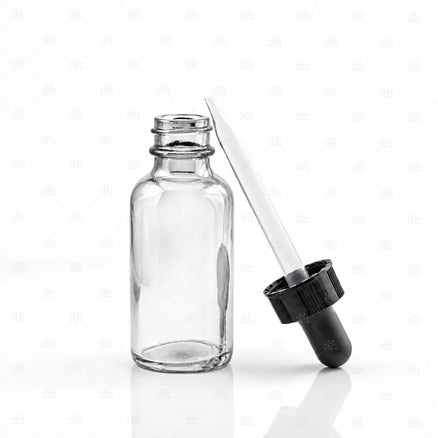 Klar glassflaske med svart pipette og gjennomsiktig glassrør på hvit bakgrunn