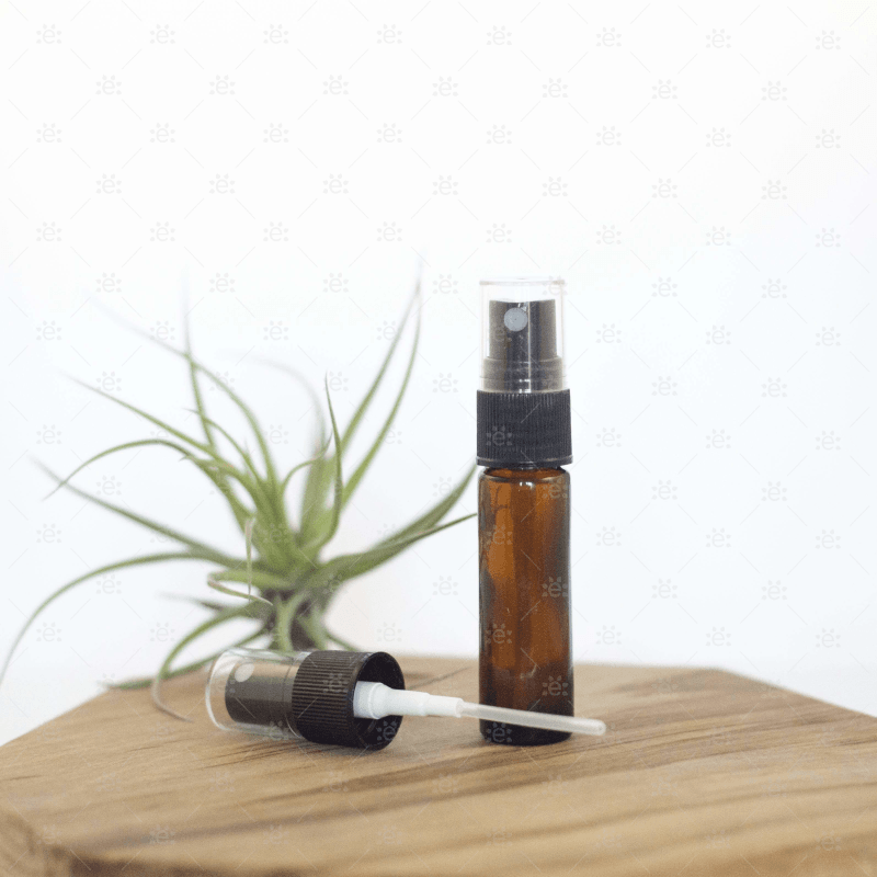 Sprayhode til 5 ml og 10 ml rollerflasker for eteriske oljer fra doTERRA vist i bruk med brun glassflaske